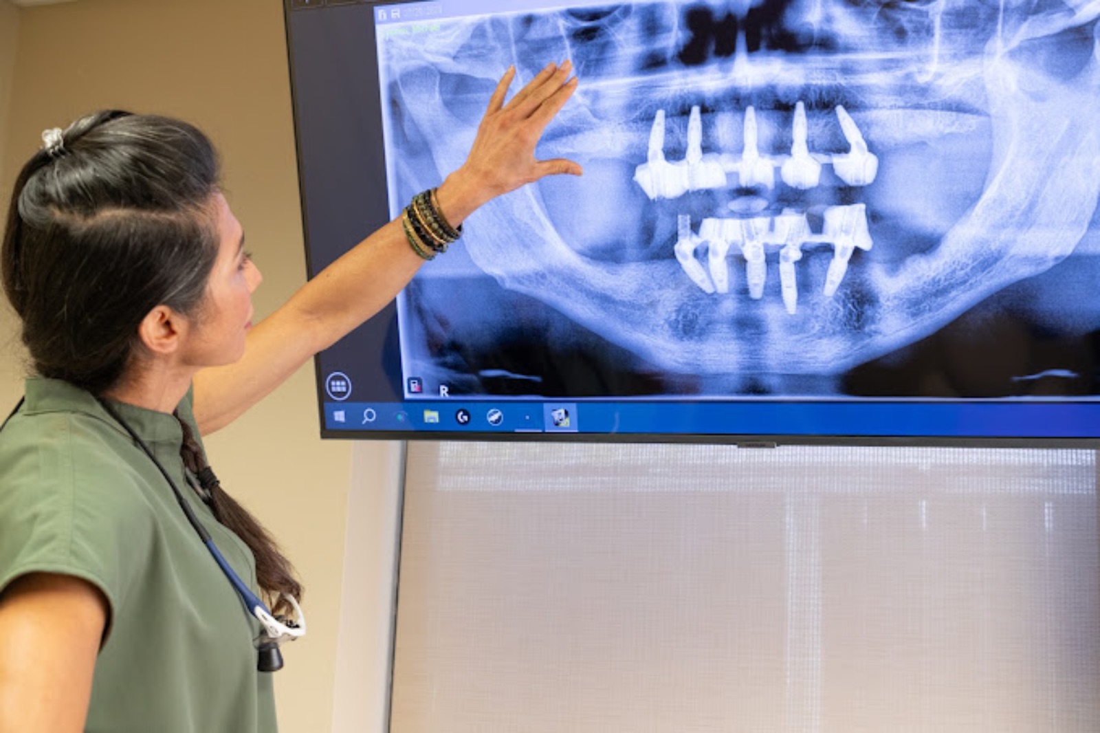 Dr. Pournik with a monitor of a teeth x-ray